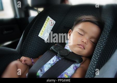 Baby girl dormire nel sedile auto mentre mamma rigidi in moderne auto compatta Foto Stock