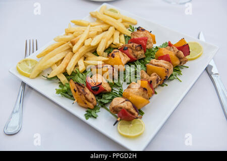 Vista dettagliata del pollo shish kebab tawook pasto sulla piastra in all'aperto ristorante di lusso impostazione Foto Stock