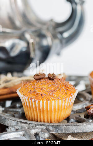 Tortine con scaglie di cioccolato circondato da caffè in grani Foto Stock