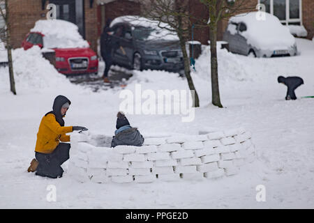 Gli adolescenti la costruzione di un igloo nell'alloggiamento. BERLINA E BREAK Neve in Irlanda Foto Stock