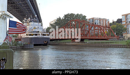 La M/V Sam narra il lago freighter passa il aperto Red Centre Street ponte girevole lungo le rive del fiume Cuyahoga in Cleveland, Ohio, USA. Foto Stock