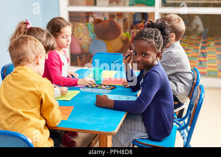 Bambini vernice con acquarello e spazzola nella classe di pittura in asilo nido o alla scuola elementare Foto Stock