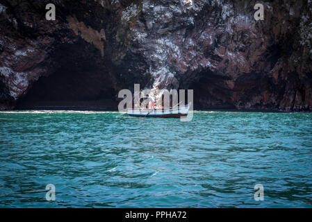 Isole Ballesta, Perù--Aprile 11, 2018. Un pescatore getta la sua linea nei pressi di una grotta ingresso in Ballesta Isole. Foto Stock