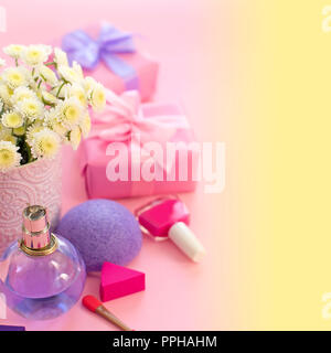 Composizione di festa con scatola regalo Vaso con fiori crisantemo cosmetici profumo spugna. Brillanti e saturi è di sfondo un gradiente di colore giallo rosa Foto Stock