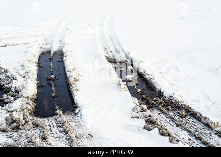 Sfondo della neve sulla strada, inverno texture con tracce di pneumatici e fango Foto Stock