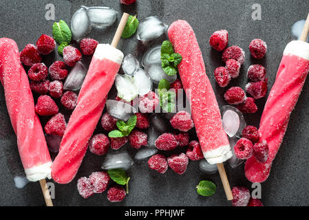 Ghiaccio aromatizzato pop dal sorbetto alla frutta con lamponi congelati Foto Stock