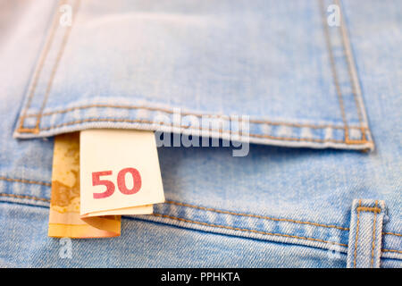 Il denaro in una tasca dei jeans Foto Stock