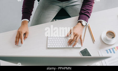 Immagine ritagliata di designer che lavora a tavola col computer in ufficio Foto Stock