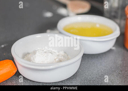 Farina bianca e le uova in un ramekin sulla cucina superficie di lavoro Foto Stock