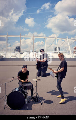 Rock band in abiti neri la riproduzione di musica su strada Foto Stock