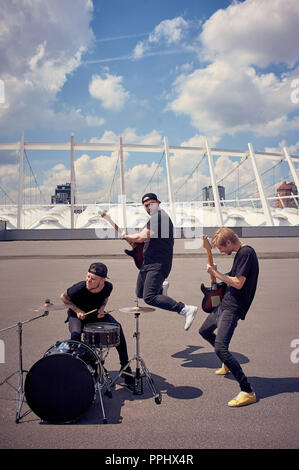 Rock band in abiti neri la riproduzione di musica su strada Foto Stock