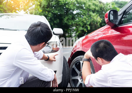 Due uomini sostenendo dopo un incidente di auto Traffic Collision sulla strada Foto Stock