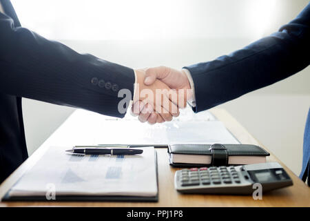 Due uomini di business partner si stringono la mano durante una riunione per trattare completare a firmare un accordo contrattuale e diventare il successo in ufficio Foto Stock