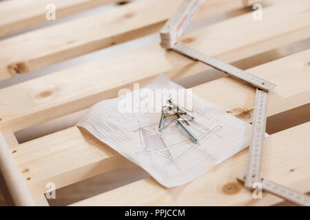 Vista da sopra le viti su istruzione e costruzione roulette, montaggio di mobili, letti in appartamento Foto Stock
