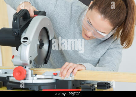 Falegname femmina utilizzando una sega circolare Foto Stock