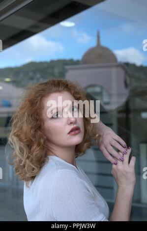 Donna contro la finestra di vetro Foto Stock