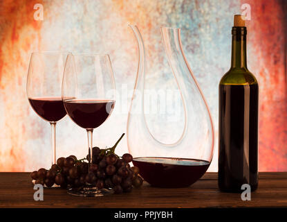 Decanter in vetro con vino rosso e uva Foto Stock