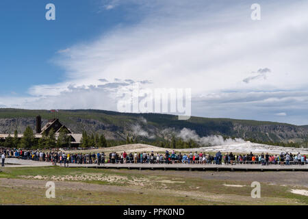 Yellowstone, Wyoming: folle di turisti e visitatori si riuniscono intorno al Boardwalk per guardare geyser Old Faithful eruttano. Concetto per crowde Foto Stock