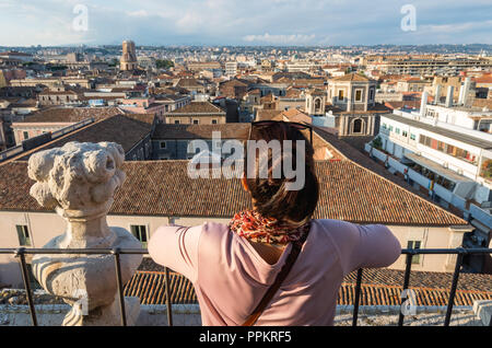 Giovane donna godendo la vista di Catania dalla torre della Chiesa della Badia di Sant'Agata, Catania, Sicilia, Italia. Foto Stock