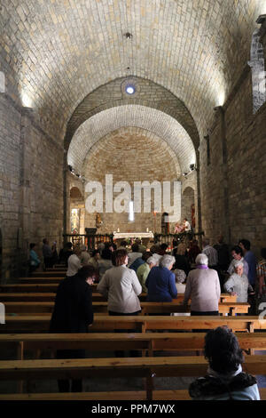 I componenti interni e l'altare di pietra romaneque Maria Santissima chiesa (Iglesia de Santa Maria) durante la celebrazione di una messa in Ainsa, Spagna Foto Stock