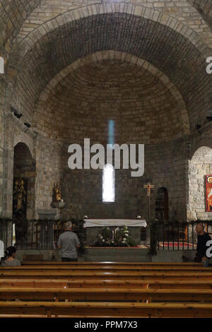 I componenti interni e l'altare di pietra romaneque Maria Santissima chiesa (Iglesia de Santa Maria) durante la celebrazione di una messa in Ainsa, Spagna. Foto Stock