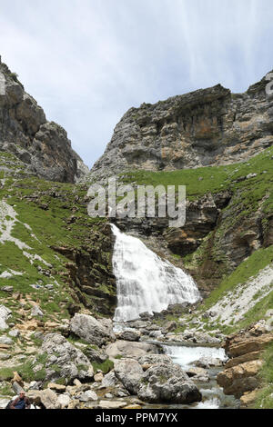 La coda di cavallo cascata (Cola de Caballo) come il fiume Arazas fluisce verso le alte montagne rocciose e i pascoli in Ordesa Valley, Aragona, Spagna. Foto Stock