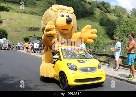 Il giallo Le Crédit Lyonnais vetture con il tipico lion mascotte gettando regali gratuiti durante il 2018 Tour de France xvii stadio Soulan, Pirenei. Foto Stock