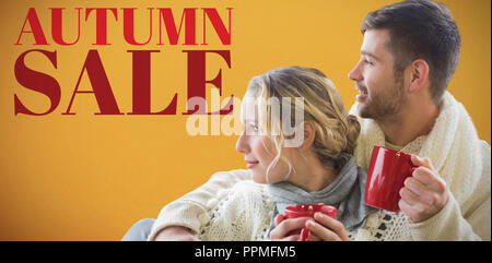 Immagine composita di allegro giovane in abbigliamento invernale poggiarvi bicchieri contro la finestra Foto Stock