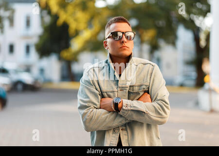 Moda uomo tanga con un taglio di capelli in una camicia di jeans in strada Foto Stock