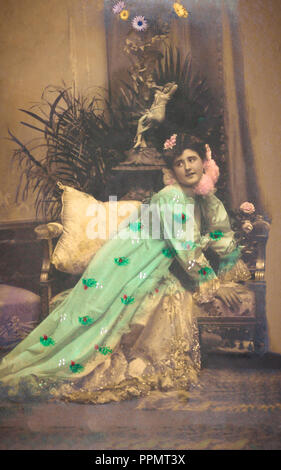 Immagine vintage di una donna in elegante abito da sera, bellissimi fiori in camera. Foto Stock