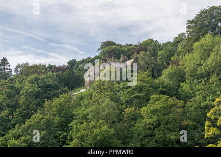 Cressbrook Hall, immerso tra gli alberi, come si vede dal Monsal Trail, Derbyshire, Regno Unito Foto Stock