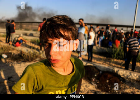 Settembre 26, 2018 - un numero di manifestanti palestinesi sono ferito da israeliani fuoco vivo e gas lacrimogeni durante gli scontri con i soldati israeliani nei pressi di Beit Hanoun traversata nel nord della Striscia di Gaza. Alcuni dei dimostranti palestinesi scagliare pietre e una granata verso i soldati israeliani sull'altro lato della recinzione. Dal marzo 30 palestinesi sono state organizzando il grande marzo di raduni di ritorno lungo il confine Gaza-Israeli rivendicano il diritto di ritorno per i rifugiati palestinesi che sono fuggiti o sono stati cacciati dalla loro patria intorno al tempo della creazione di Israele. Essi hanno anche ca Foto Stock