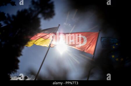27 settembre 2018, Berlino: il turco e tedesco sono bandiere sventolano al vento sulla parte militare di Tegel Airport prima dell'arrivo del Presidente turco Erdogan. Erdogan arriva in Germania per una tre giorni di visita di stato. Foto: Kay Nietfeld/dpa Foto Stock