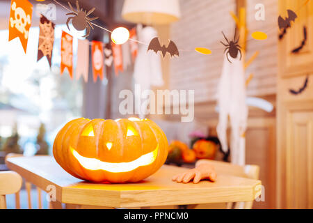 Close up scolpito zucca di Halloween con candela interna permanente sulla tabella Foto Stock