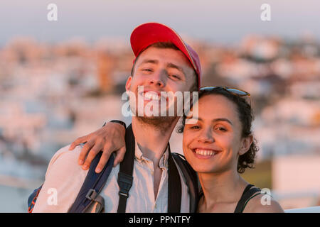 Giovane donna e giovane uomo cercando felicemente alla fotocamera, giovane, Plaza de la Encarnación, Siviglia, Andalusia, Spagna Foto Stock