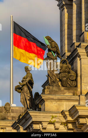 Repubblica federale di Germania, Tedesco bandiera nazionale presso il palazzo del Parlamento sventola sul cielo blu sullo sfondo Foto Stock