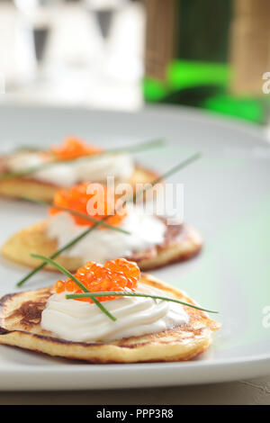 Blinis con caviale rosso su una piastra Foto Stock