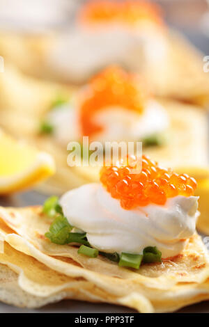 Crepes con caviale rosso su una piastra Foto Stock