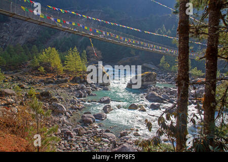 Ponte di sospensione e di preghiera flags over il Dudh Kosi river Foto Stock