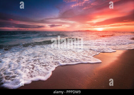 Incredibilmente bellissimo tramonto sulla spiaggia in Thailandia. Sole, il cielo, il mare, le onde e la sabbia. Una vacanza in riva al mare Foto Stock