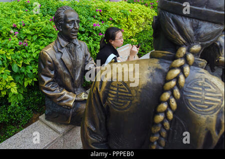 Singapore, sculture a grandezza naturale raffiguranti mercanti di negoziazione del passato lungo il fiume Singapore. Foto Stock