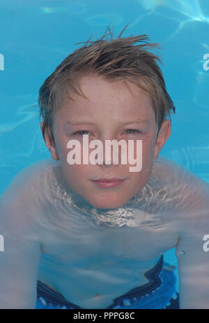 Dieci anno il ragazzo in una piscina. Foto Stock