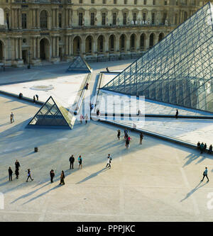 Piramide di vetro e molte persone che camminano nel Louvre, Parigi, Francia. Foto Stock