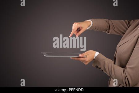 Mano femminile in tuta azienda tablet con nessun wallpaper Foto Stock