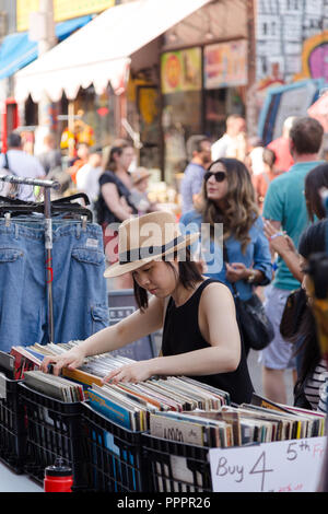 TORONTO, ON, Canada - 29 luglio 2018: una giovane donna asiatica navigando attraverso l'annata record in Toronto Kensington market. Foto Stock