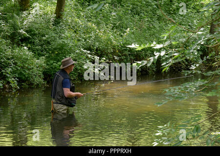 Fisherman indossando waders in fiume Derbyshire Inghilterra Foto Stock