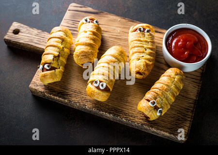 Cibo di Halloween. Scary salsiccia mummie in pasta. Foto Stock