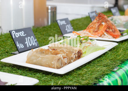 La carta coaster con la porzione od arrosti di involtini primavera con variazione di verdure. Asia street market alimentare. Foto Stock