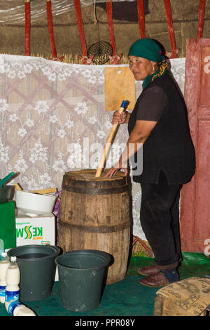 Donna del Kirghizistan kumis miscelazione durante il processo di fermentazione, Song Kol, provincia di Naryn, Kirghizistan, Asia centrale Foto Stock