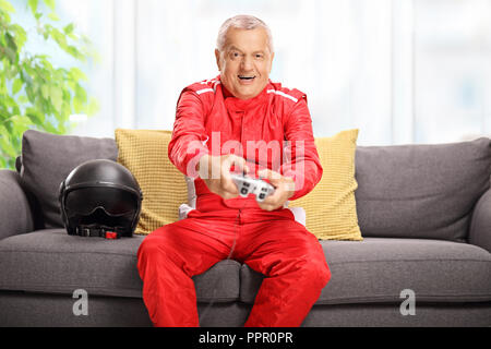 Racer seduto su un divano per giocare con i videogiochi in ambienti interni Foto Stock